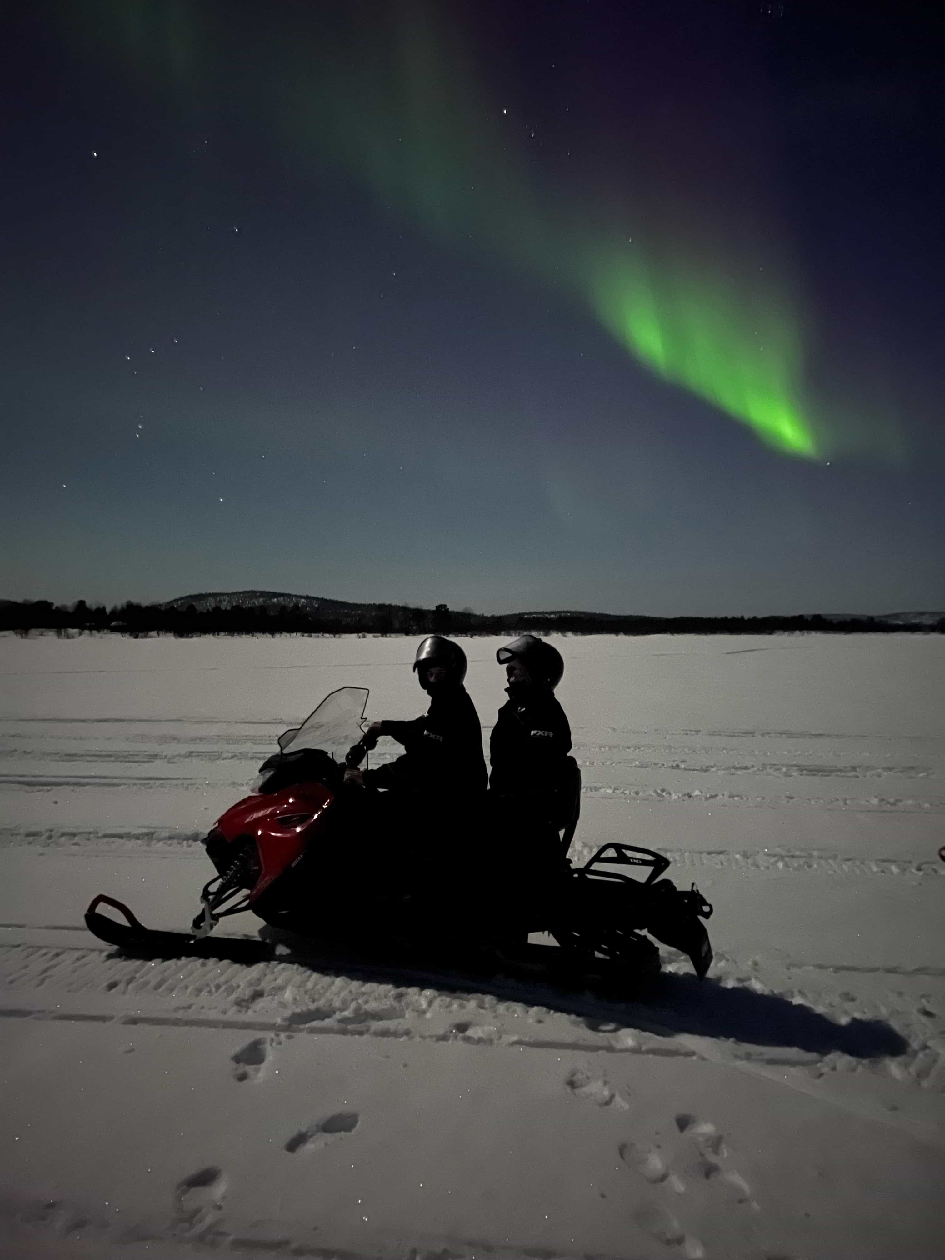 THE AURORA BOREALIS HUNTING BY SNOWMOBILE