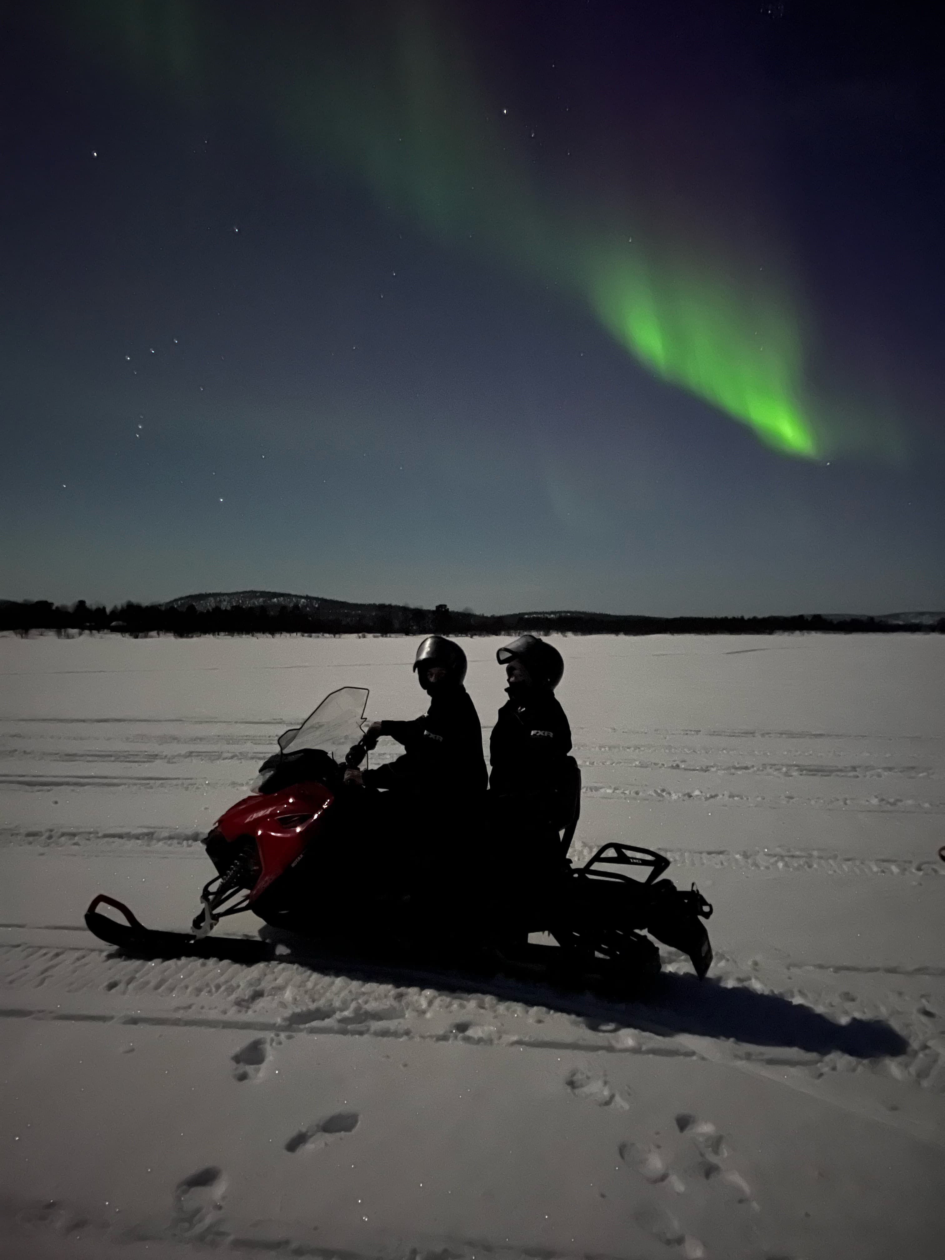 THE AURORA BOREALIS HUNTING BY SNOWMOBILE